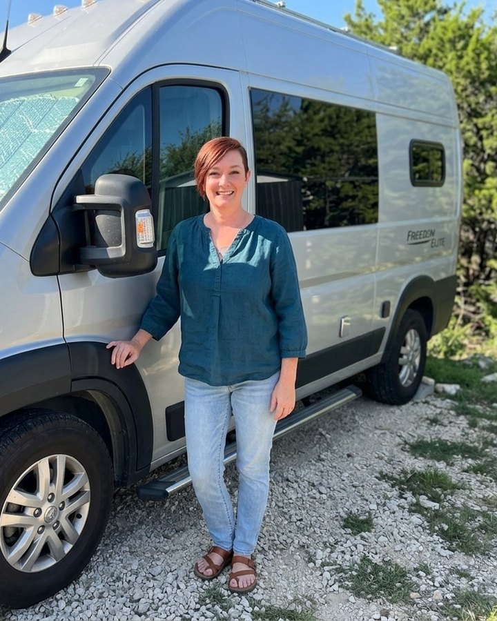 Katherine, owner of CampsiteDesk, beside her camper van